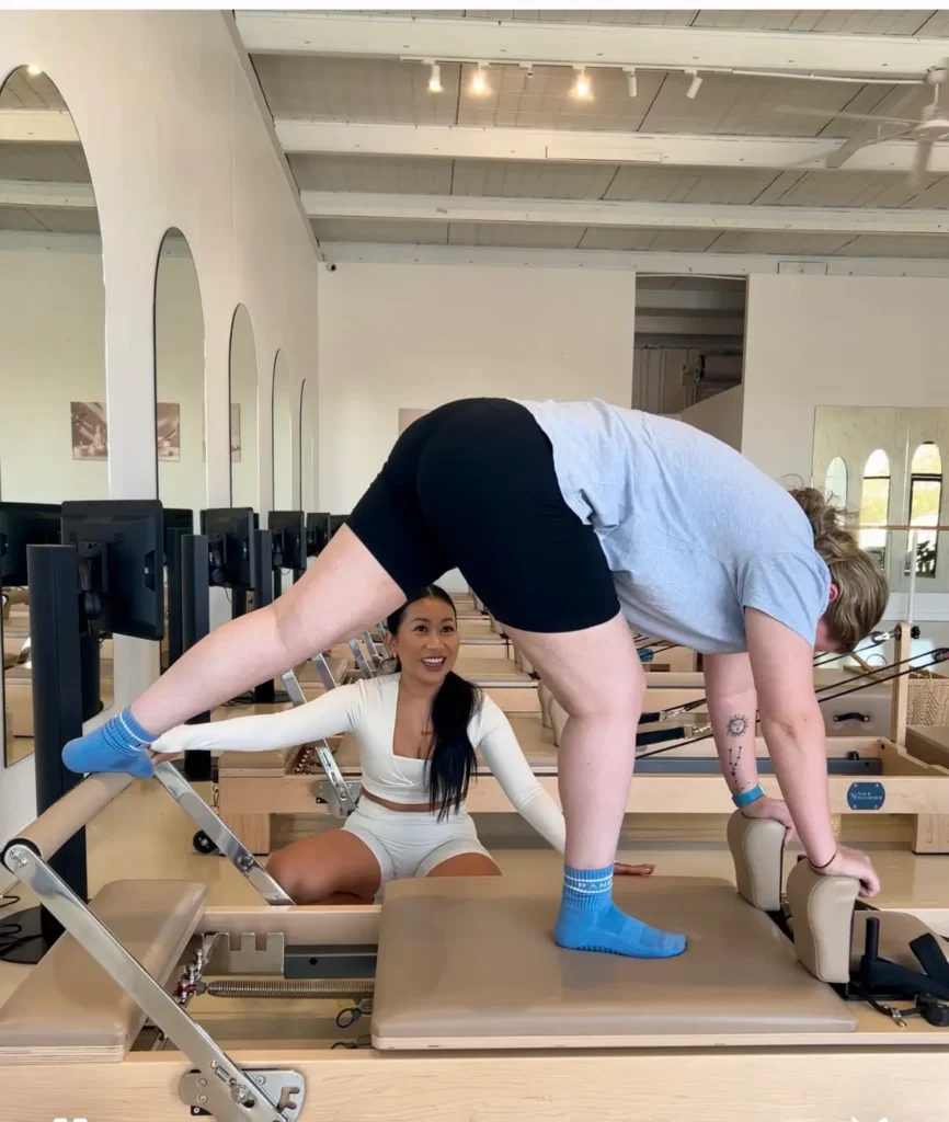 Instructor guiding client in a private reformer Pilates session at om pilates Southport studio